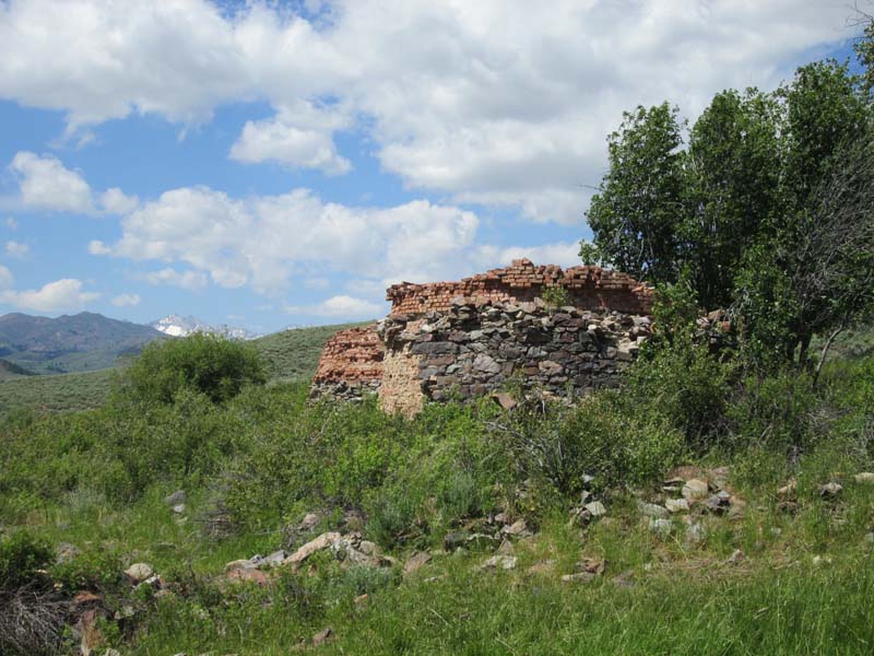 7.-Two-of-the-remaining-charcoal-kilns-at-Muldoon-with-Pioneer-Range-at-center-left.-The-kilns-once-were-complete-beehive-shaped-structures.