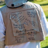 Participants of the Reel Recovery trip sign each other\'s fishing vests