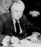President Franklin D. Roosevelt signing the Declaration of War